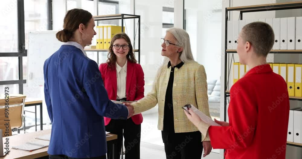 Mature seo business woman shaking hands with businessman in negotiating meeting. Senior executive woman shaking hands and welcoming new hire partner