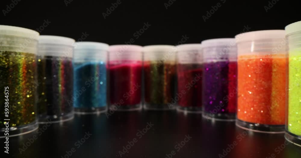Set of colorful sparkling eyeshadows in jars on black background. Bright glitter for manicure Set of colorful sparkling eyeshadows in jars on black background. Bright glitter for manicure