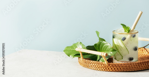 Banner. Trendy summer drink with cucumber  mint and blueberry on blue sky background  copy space