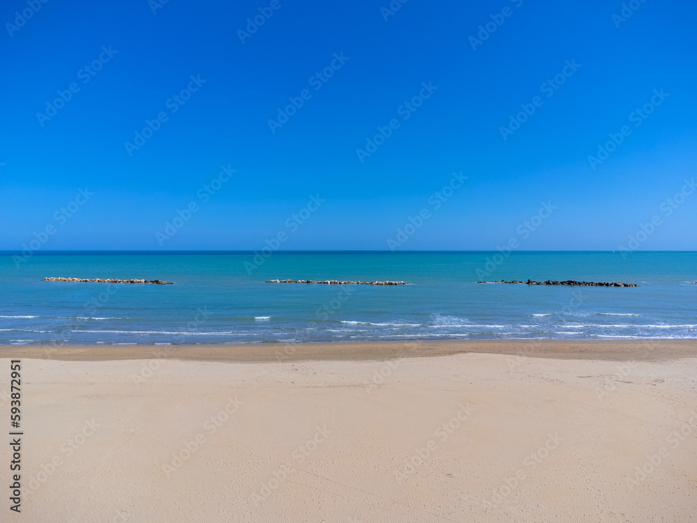 Aerial view landscape Italy Pescara. Empty beach and sea, waves, sand. Photo from a drone. Blue sky.