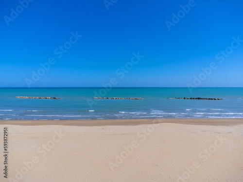 Obraz na płótnie Aerial view landscape Italy Pescara. Empty beach and sea, waves, sand. Photo from a drone. Blue sky. w salonie