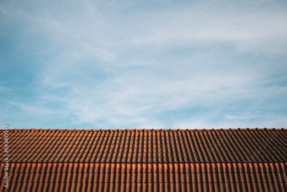 Le ciel bleu des Hauts-De-France où la brique et les tuiles oranges sont présentes.