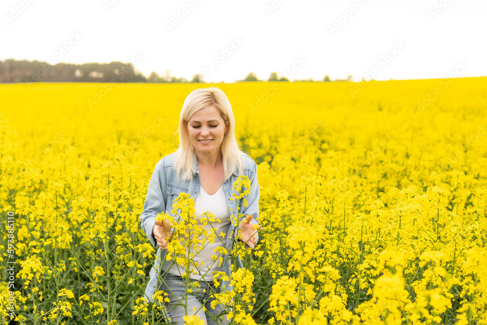 Portrait of young beautiful woman in blooming rapeseed meadow Portrait of young beautiful woman in blooming rapeseed meadow
