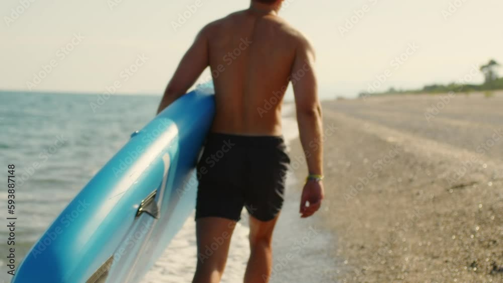 Man with paddle sup board on the beach 