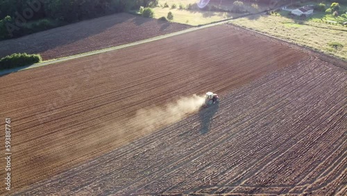 Engin agricole dans un grand champ labouré travaillant dans un environnement sec et aride