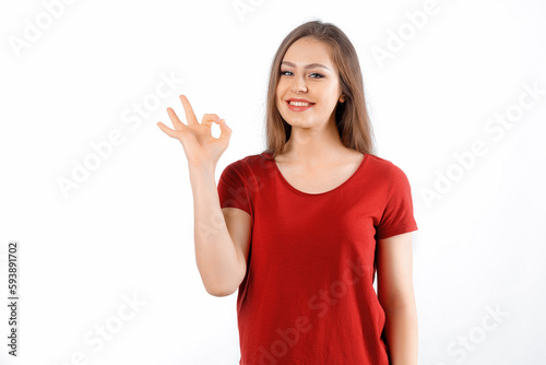 Okay, perfect. Smiling beautiful brunette girl, showing ok, zero gesture, no problem sign, recommending something, standing satisfied against white background