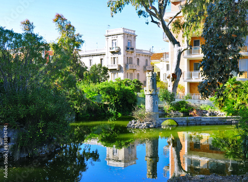 Villa comunale con palazzo liberty che si rispecchia nel lago con la fontana artistica