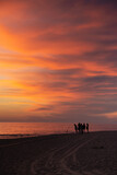 un groupe à contre-jour au coucher du soleil au bord de la mer