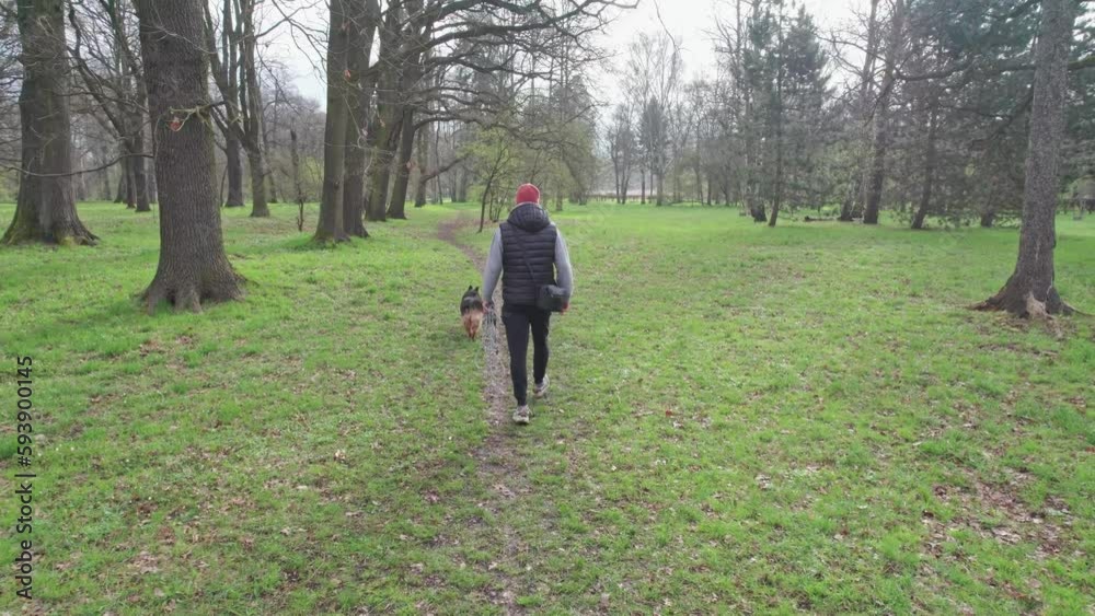 The city park is the perfect place for a man to walk his dog and enjoy the unbreakable bond between man and animal that comes with being an urban pet owner. The city park is the perfect place for a man to walk his dog and enjoy the unbreakable bond between man and animal that comes with being an urban pet owner.