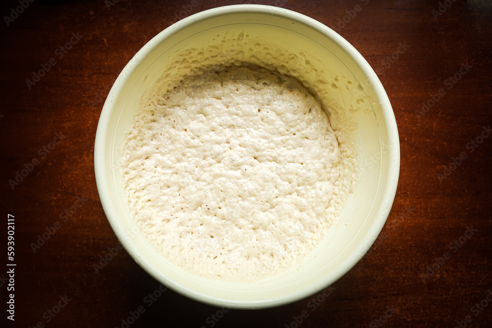 the process of cooking cooking dough in a yellow toe on a dark wooden table. the process of cooking cooking dough in a yellow toe on a dark wooden table.