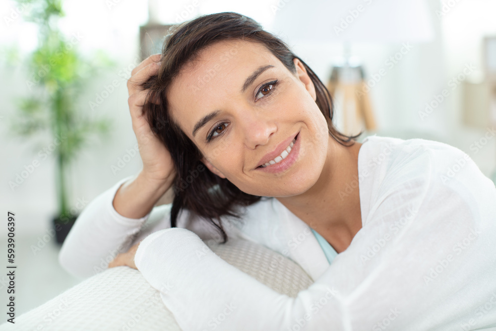 happy woman sitting leaned on couch at home happy woman sitting leaned on couch at home
