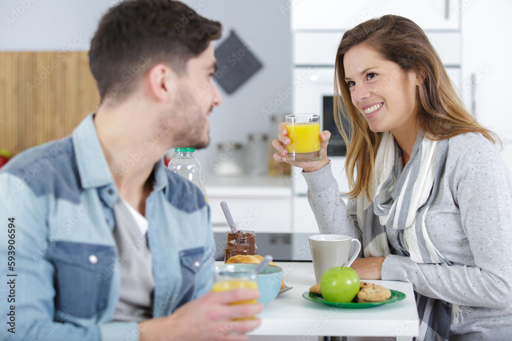 young couple chatting while having breakfast at home young couple chatting while having breakfast at home