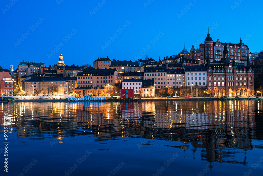Stockholm Södermalm at twilight, buildings reflecting in water.