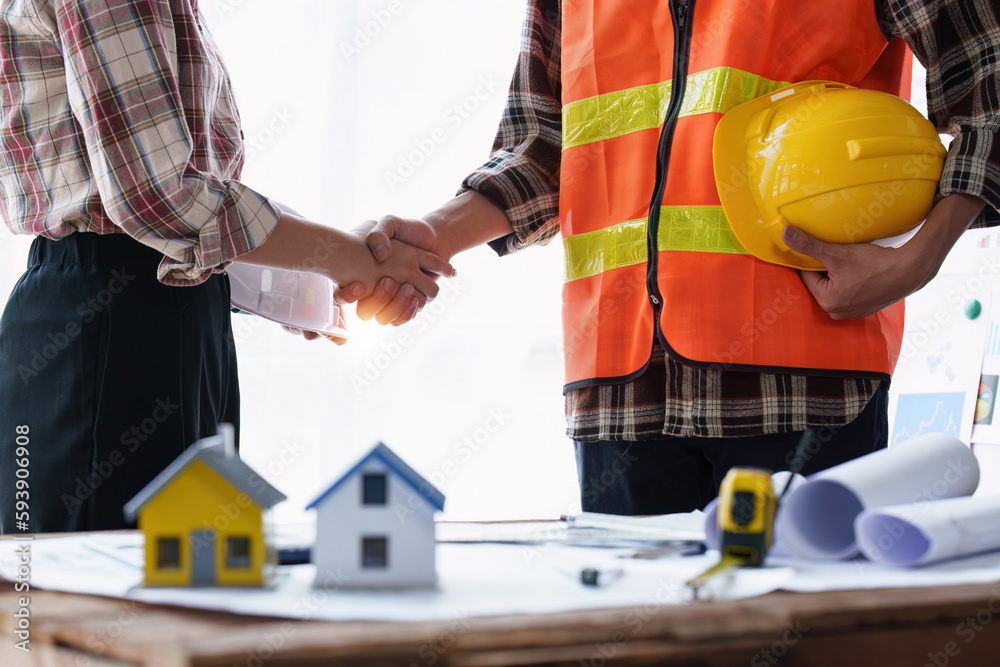 Architect and Engineer working with blueprints for architectural plan, engineer sketching a construction project, green energy concept