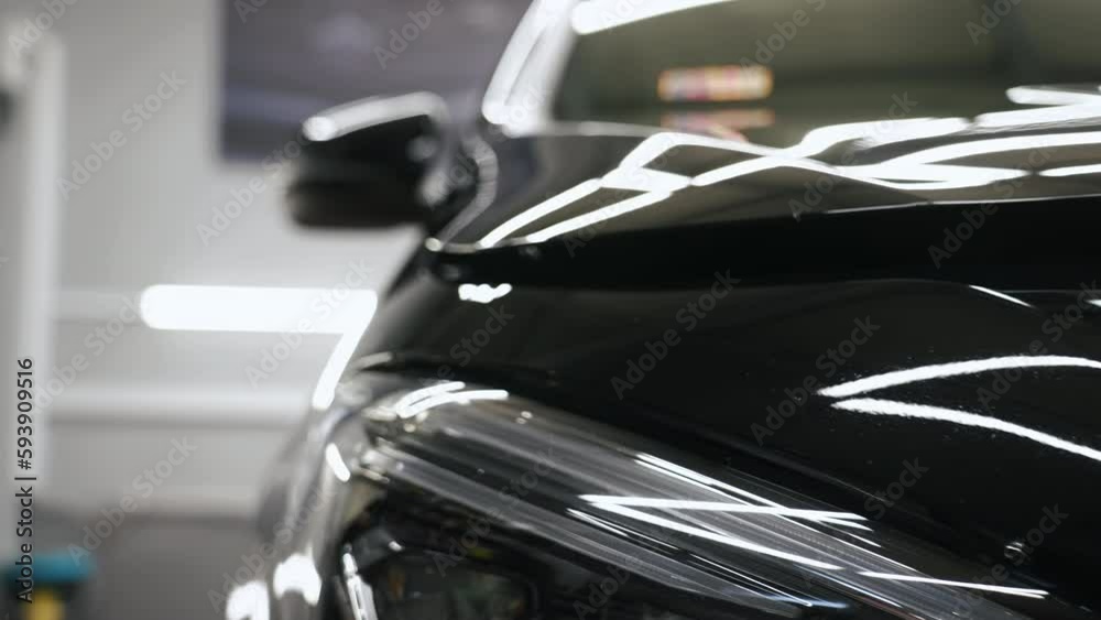 Camera moving from a black car's mirror to the hood. Close shot video. High quality 4k footage