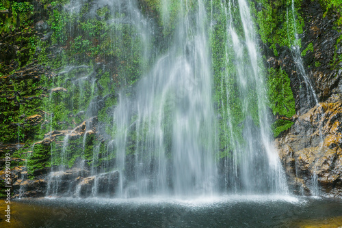 Fototapeta Naklejka Na Ścianę i Meble -  A waterfall cascading over moss covered rocks near Sapa in Vietnam