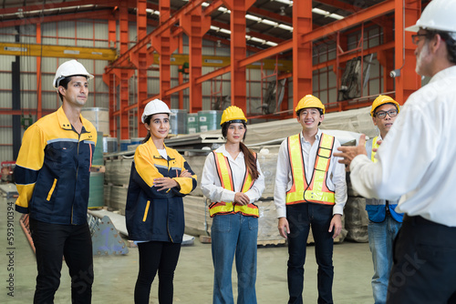 Manufacturing industrial factory concept. Group of male and female factory workers working, meeting and discuss at manufacturing production lines in factory during manufacturing process © amorn