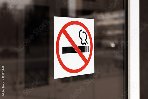 A no smoking sign is affixed to the glass door. Angle view.