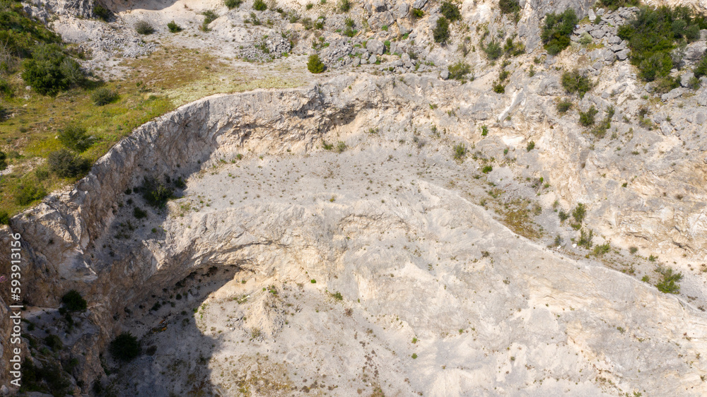 Aerial view of an abandoned stone quarry. There is no one in the mine and the mine site is empty.