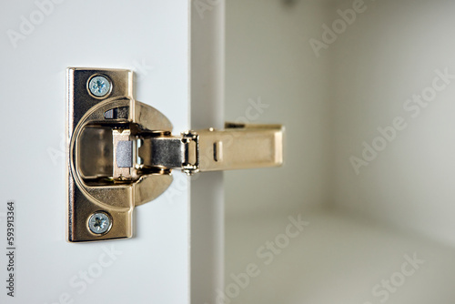 Hinge cabinet of kitchen cupboard door golden metal furniture isolated on white background, hardware on wood with copyspace.