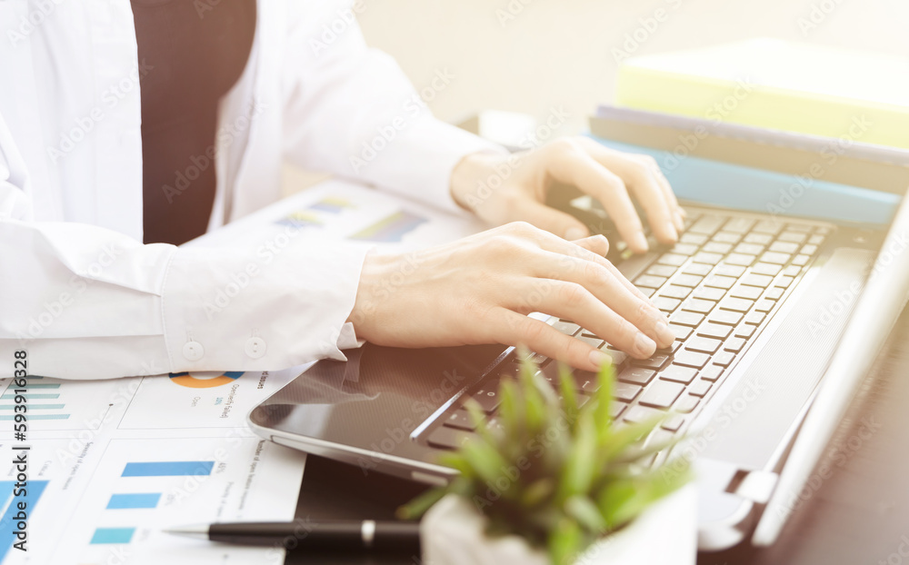 Closeup of a female hands busy typing on a laptop. Blured foreground. Closeup of a female hands busy typing on a laptop. Blured foreground.