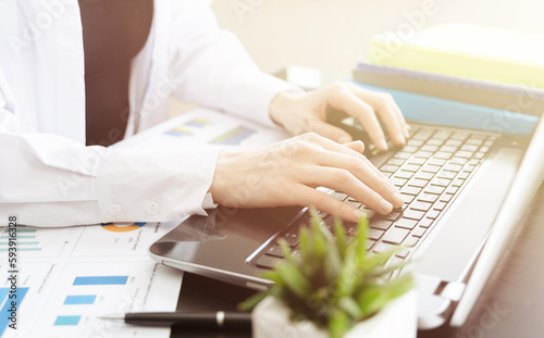 Closeup of a female hands busy typing on a laptop. Blured foreground.