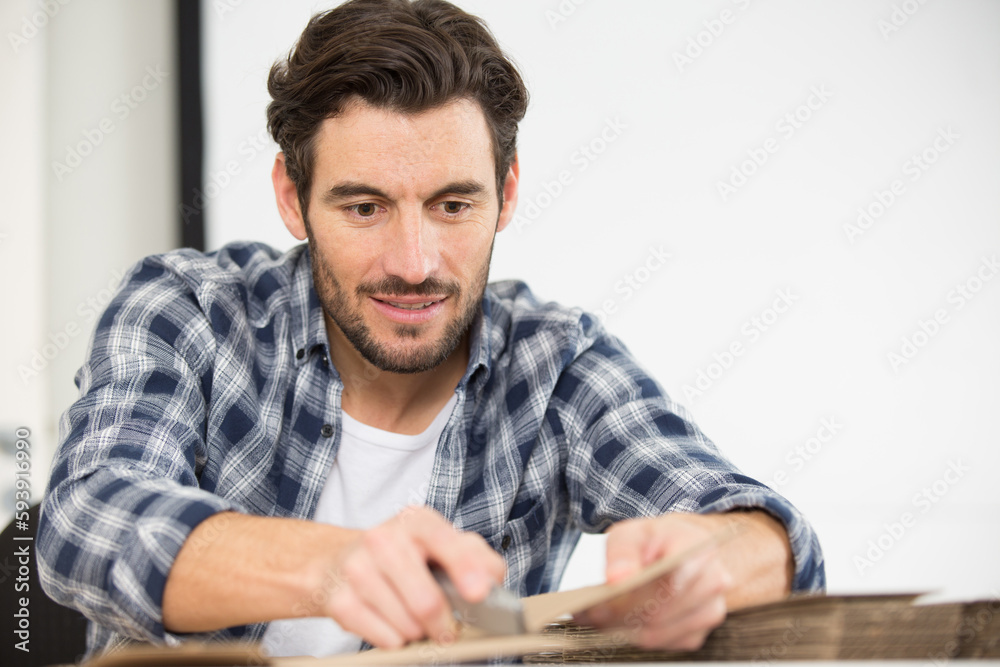 man cuts a box with a stationery knife man cuts a box with a stationery knife
