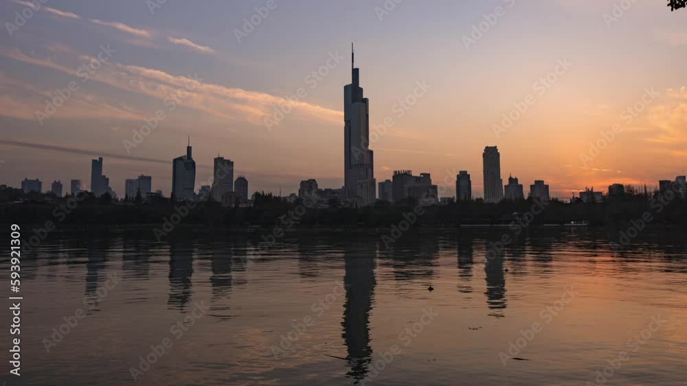 Time-lapse of a cityscape with a lake in the foreground in the evening Time-lapse of a cityscape with a lake in the foreground in the evening