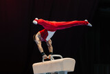 male gymnast performing on pommel horse competition artistic gymnastics, black background
