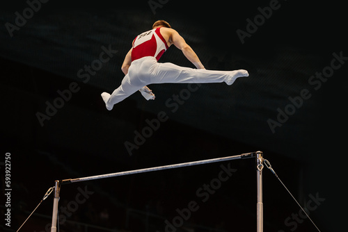 gymnast performing on horizontal bar competition artistic gymnastics, black background photo