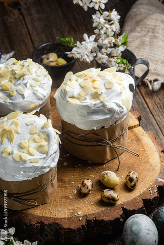 Easter cake with meringue and almond petals on a wooden background