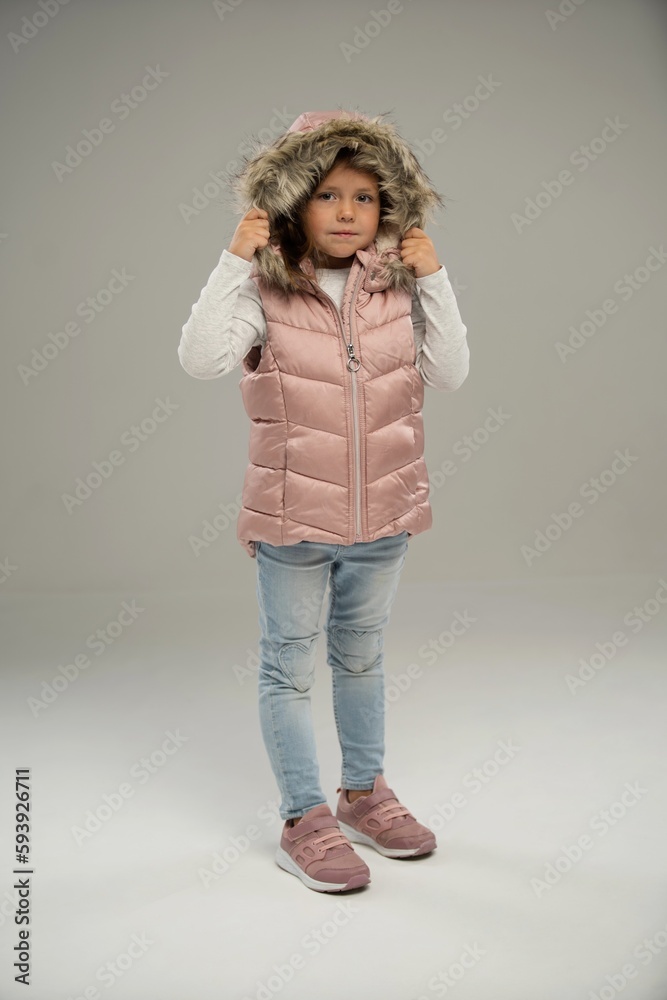 Full length of little girl, child, posing in warm jacket and hat isolated over white background. Copy space for ad Full length of little girl, child, posing in warm jacket and hat isolated over white background. Copy space for ad