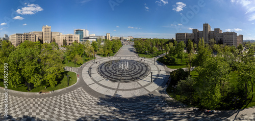 Aerial view on Karazin National University buildings on Freedom Square with circle fountain in spring green Kharkiv, Ukraine