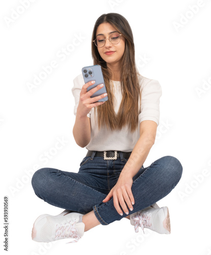 Using smartphone, caucasian woman using smartphone. Holding modern mobile phone with three cameras one hand. Sitting on the ground crossed legs. Isolated white background, copy space. Mobile app.
