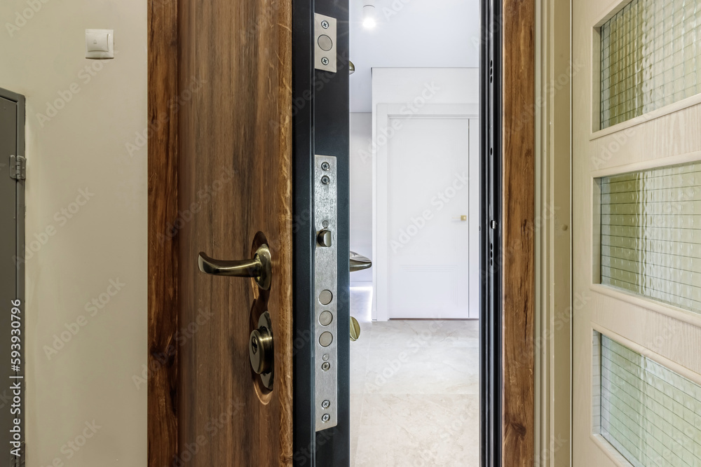 Entrance wooden door of natural color, in a multi-storey building. Entrance to the apartment