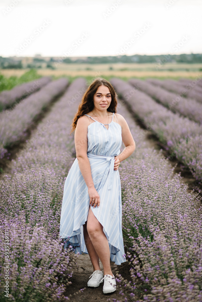 A woman in a dress walks in a lavender field at sunset. Female on a background of lavender flowers. France, Provence. Girl enjoy the floral glade, summer nature. Natural cosmetics and beauty concept. A woman in a dress walks in a lavender field at sunset. Female on a background of lavender flowers. France, Provence. Girl enjoy the floral glade, summer nature. Natural cosmetics and beauty concept.
