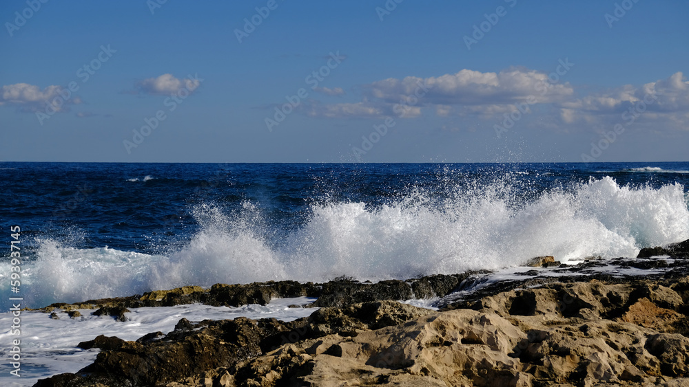 Blue sea wave and white foam and splash. Stone beach on island of Malta, no sandy beach. Summer holiday border frame concept. Tropical island vacation backdrop. Tourist travel banner design template.