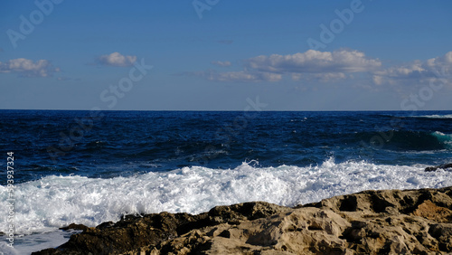 Blue sea wave and white foam and splash. Stone beach on island of Malta, no sandy beach. Summer holiday border frame concept. Tropical island vacation backdrop. Tourist travel banner design template.