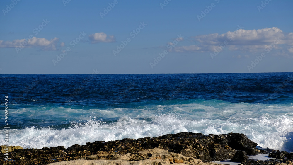 Blue sea wave and white foam and splash. Stone beach on island of Malta, no sandy beach. Summer holiday border frame concept. Tropical island vacation backdrop. Tourist travel banner design template.