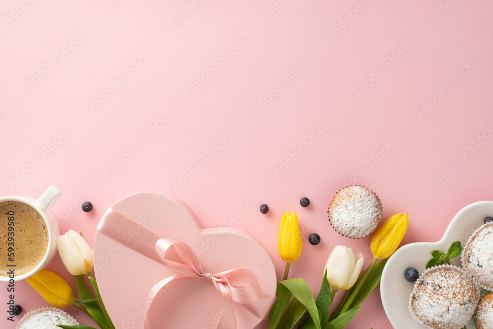 Celebrate Mother's Day in a trendy style with a top view flat lay of delicious cupcakes, presents, coffee cup, and tulips on a pastel pink background with an empty space for your message or text