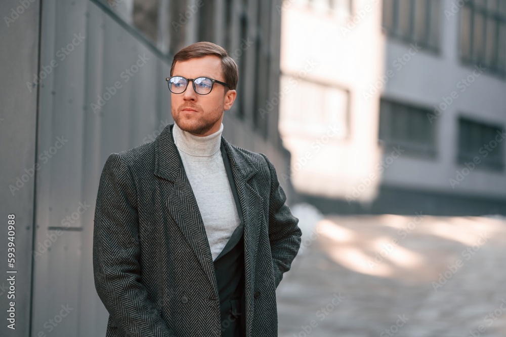 Portrait of handsome man that is in formal clothes is outdoor near the business building Portrait of handsome man that is in formal clothes is outdoor near the business building