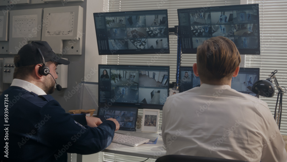 Fotka „Security officers sit in observation room and monitor CCTV