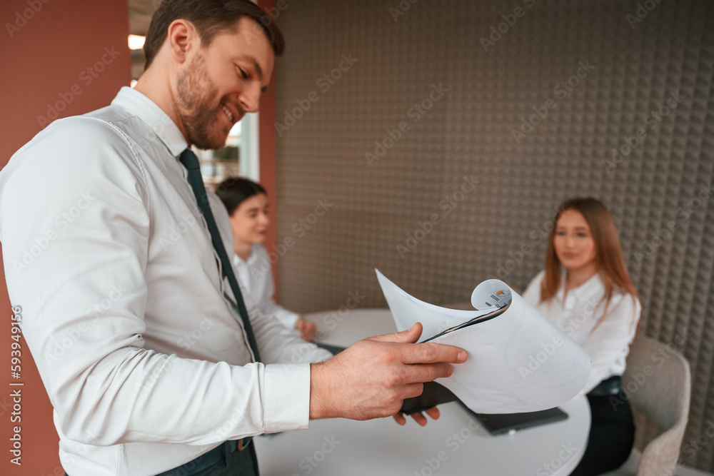 Manager is showing the plan project. Three business people are working in the office together Manager is showing the plan project. Three business people are working in the office together