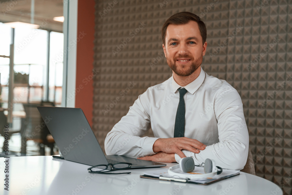 Fototapeta premium Handsome man in formal clothes is working by laptop in the office