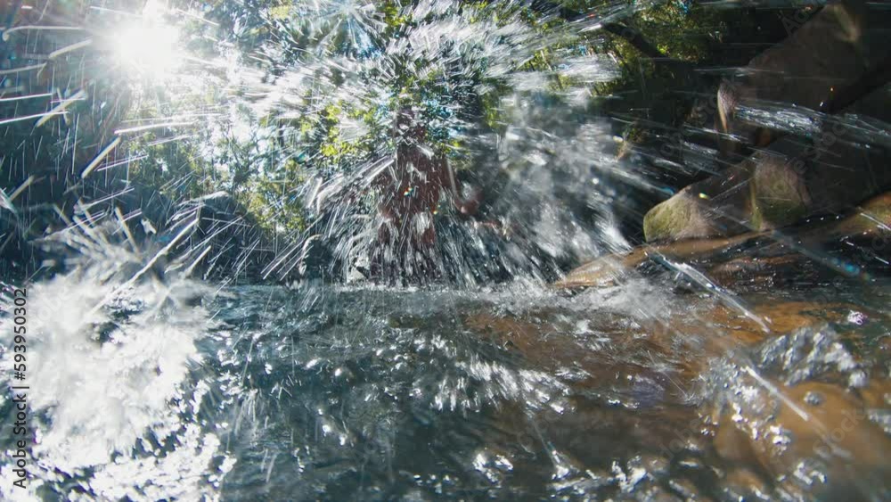 Forest lake. Man stands in the lake in a forest and splashes the water into camera Forest lake. Man stands in the lake in a forest and splashes the water into camera