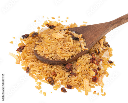 Heap of dry bulgur in wooden spoon isolated on white