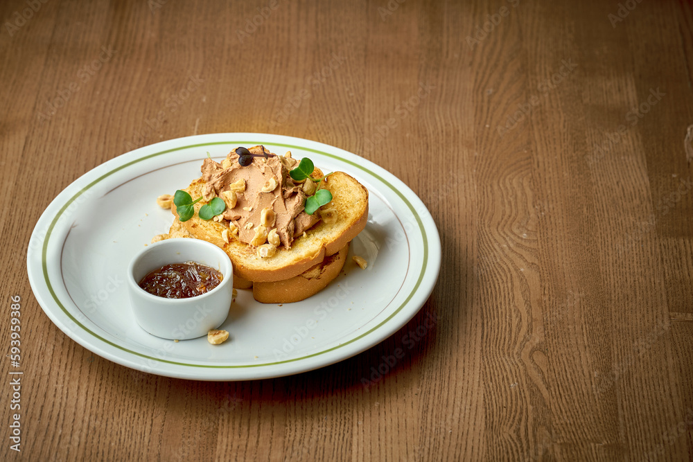 Toast with pate and nuts in a plate on a wooden background Toast with pate and nuts in a plate on a wooden background