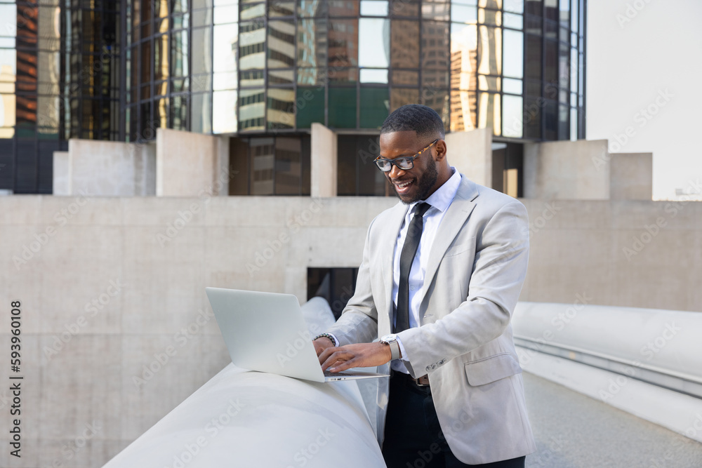 Fototapeta premium Successful Black Manager Using Computer In Front OF Modern Office Buildings