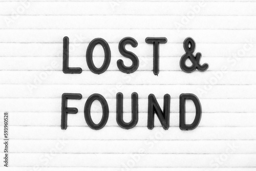 Black color letter in word lost and found on white felt board background