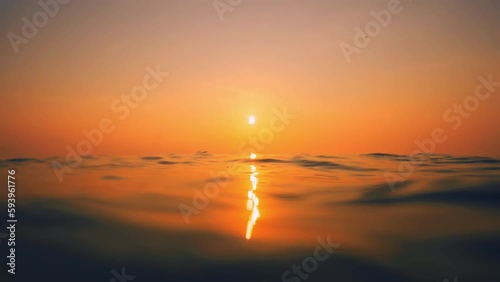 Slow Motion ocean surface from underwater at sunset with rays of light. Crystal clear breaking ocean wave with waving waterline. Sunrise over calm sea. Dawn over horizon, ocean, water - timelapse or